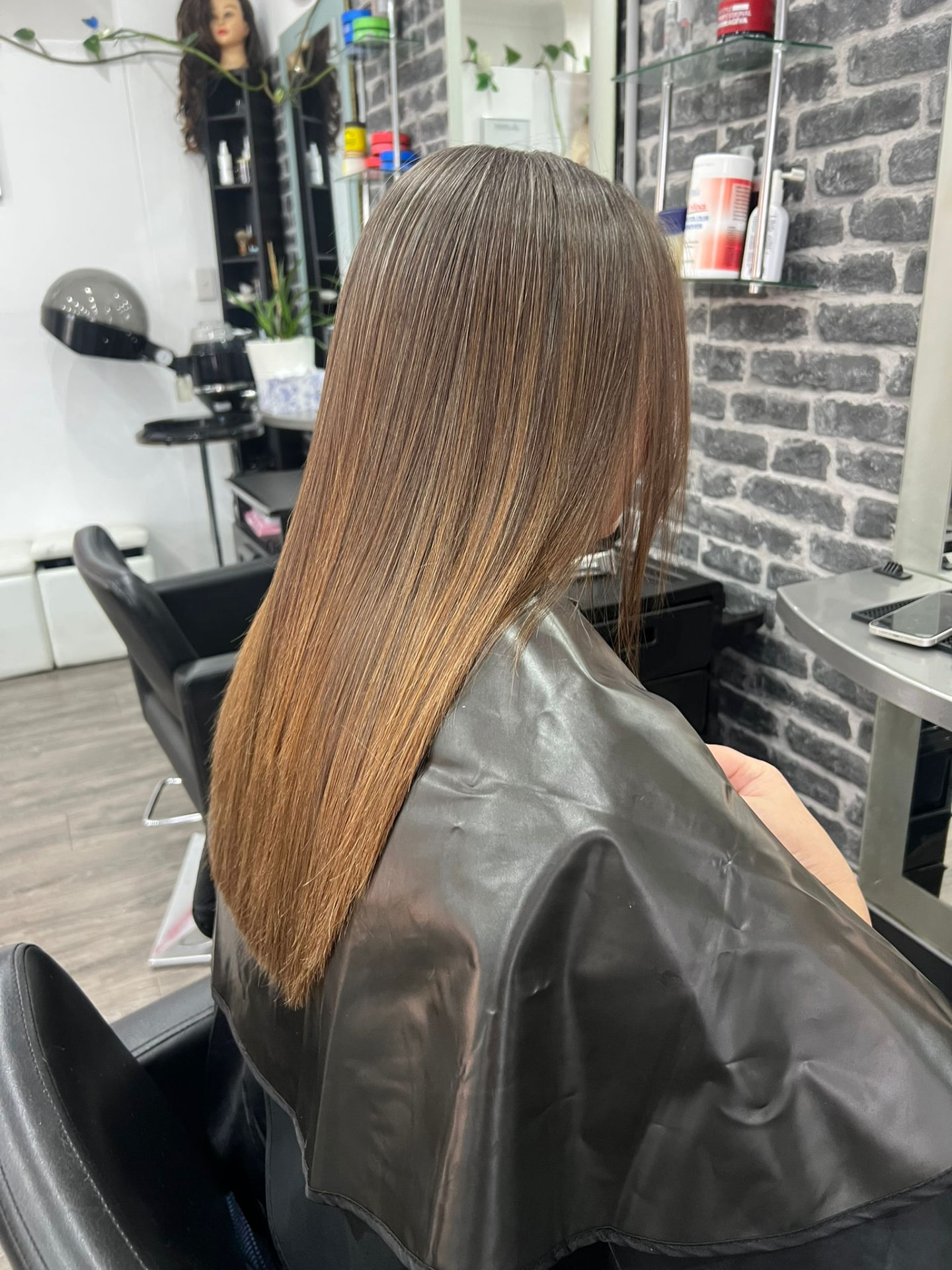 Glossy straight brunette hair after a keratin smoothing treatment